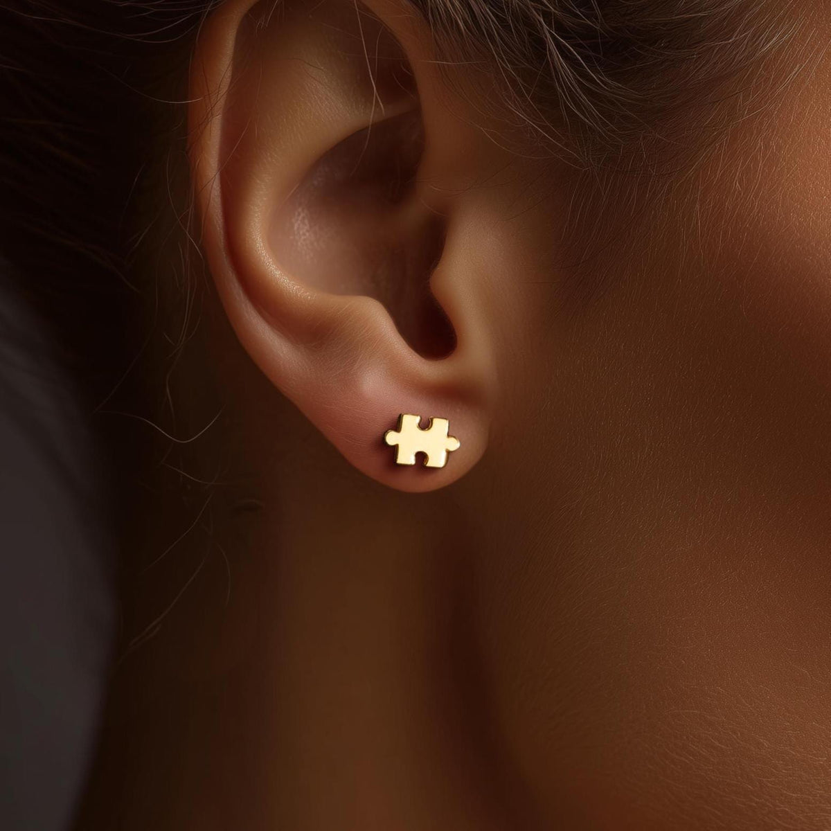 Pair of small gold puzzle piece stud earrings with a tab and notch