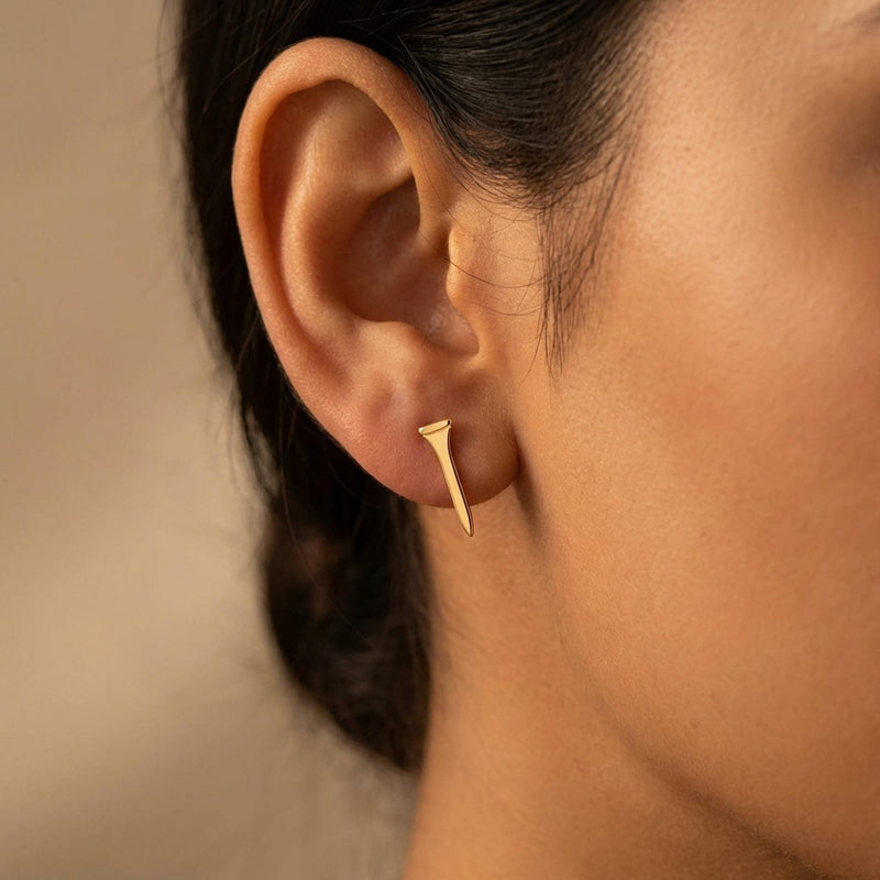 Pair of narrow gold golf tee stud earrings standing upright, front view. (5 of 10)