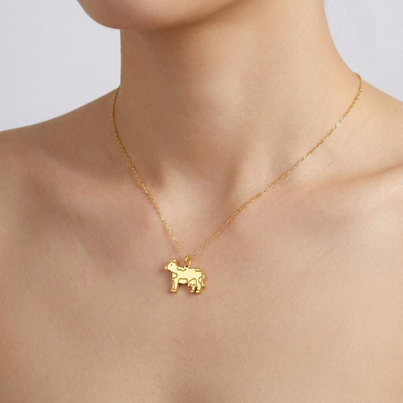 Small gold cow charm in profile on a fine cable chain necklace