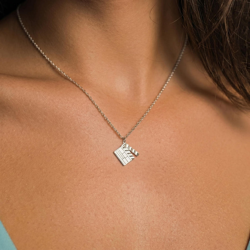 Flat gold film clapboard pendant with a striped hinged arm on a fine chain. (3 of 6)