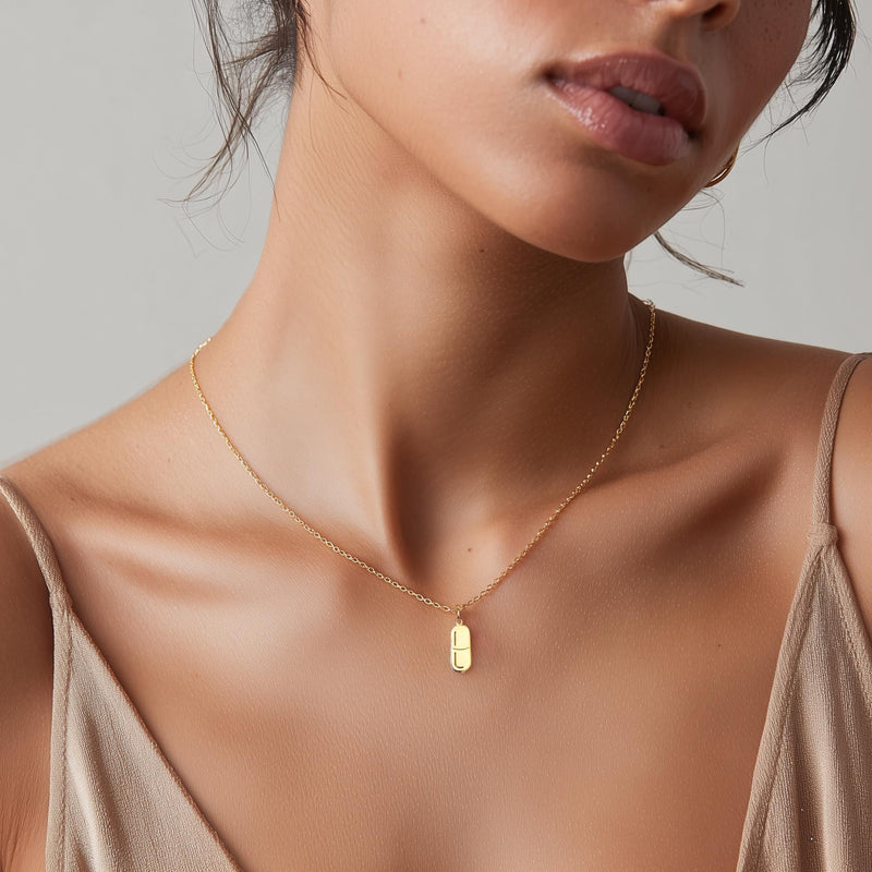 Small gold pill capsule pendant hanging from a fine cable chain. (6 of 9)