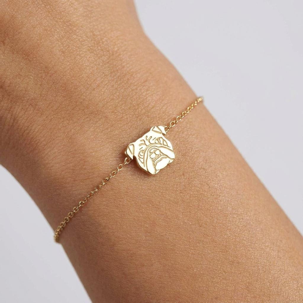 Fine chain bracelet with a small flat bulldog face charm in gold