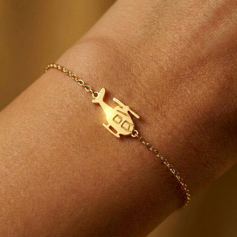 Fine chain bracelet with a small gold helicopter charm