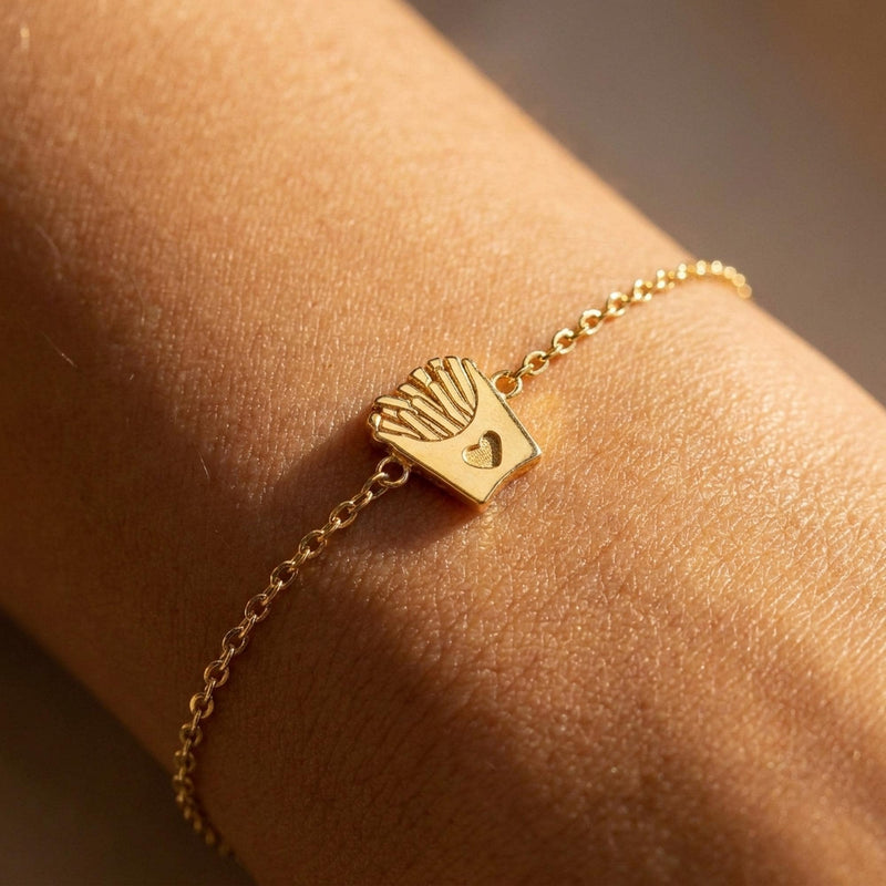 Fine gold chain bracelet with a tiny carton of french fries charm, on white (2 of 8)