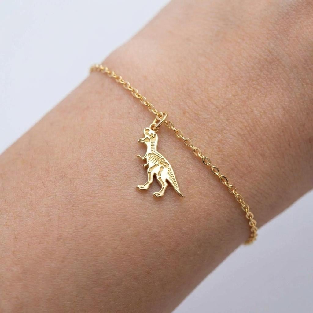 Fine gold chain bracelet with a small T-Rex skull fossil charm