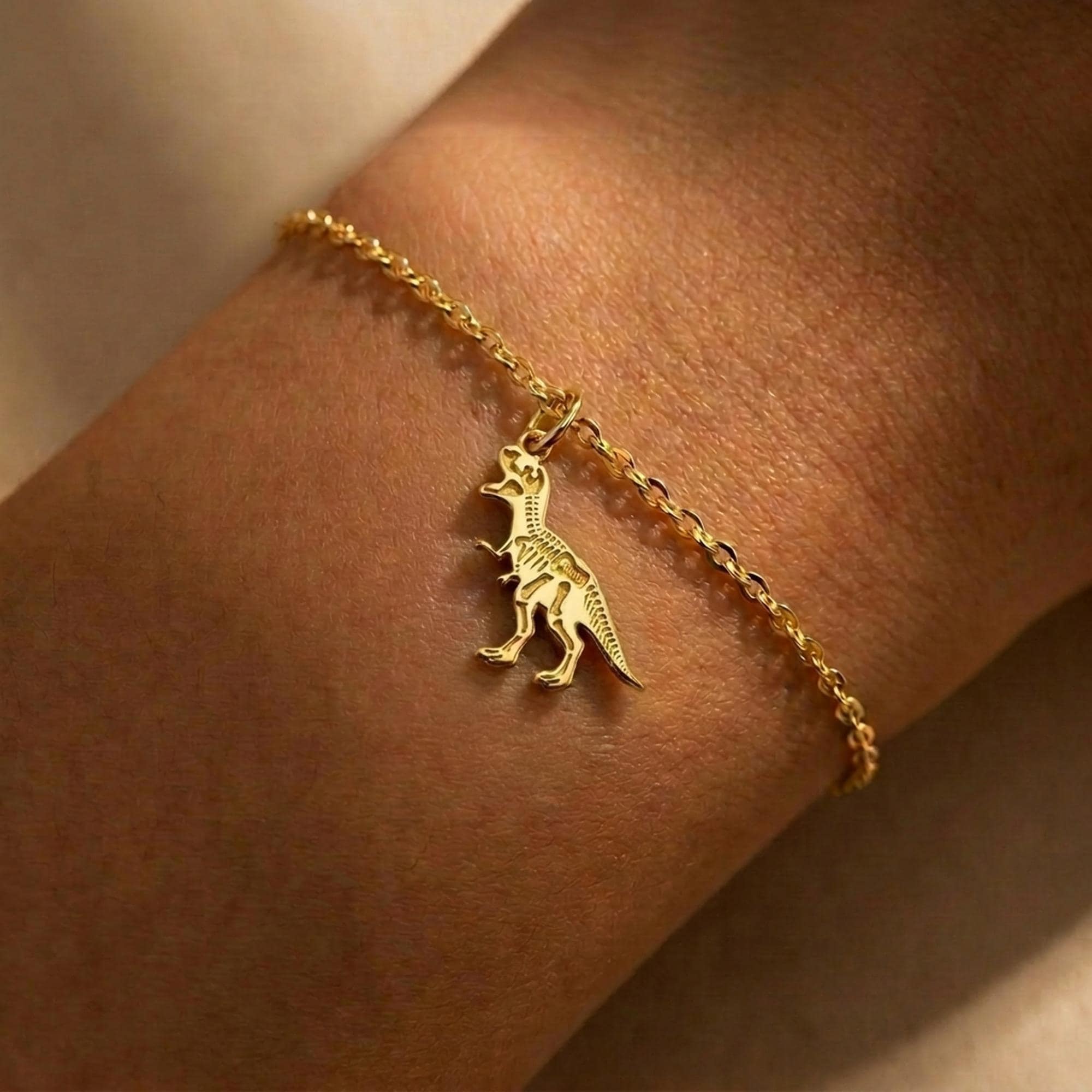 Fine gold chain bracelet with a small T-Rex skull fossil charm (2 of 8)