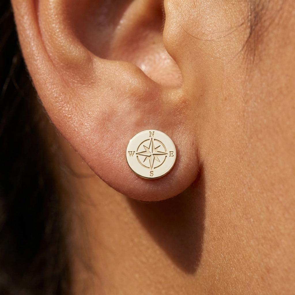Pair of very small gold compass rose stud earrings with four points.