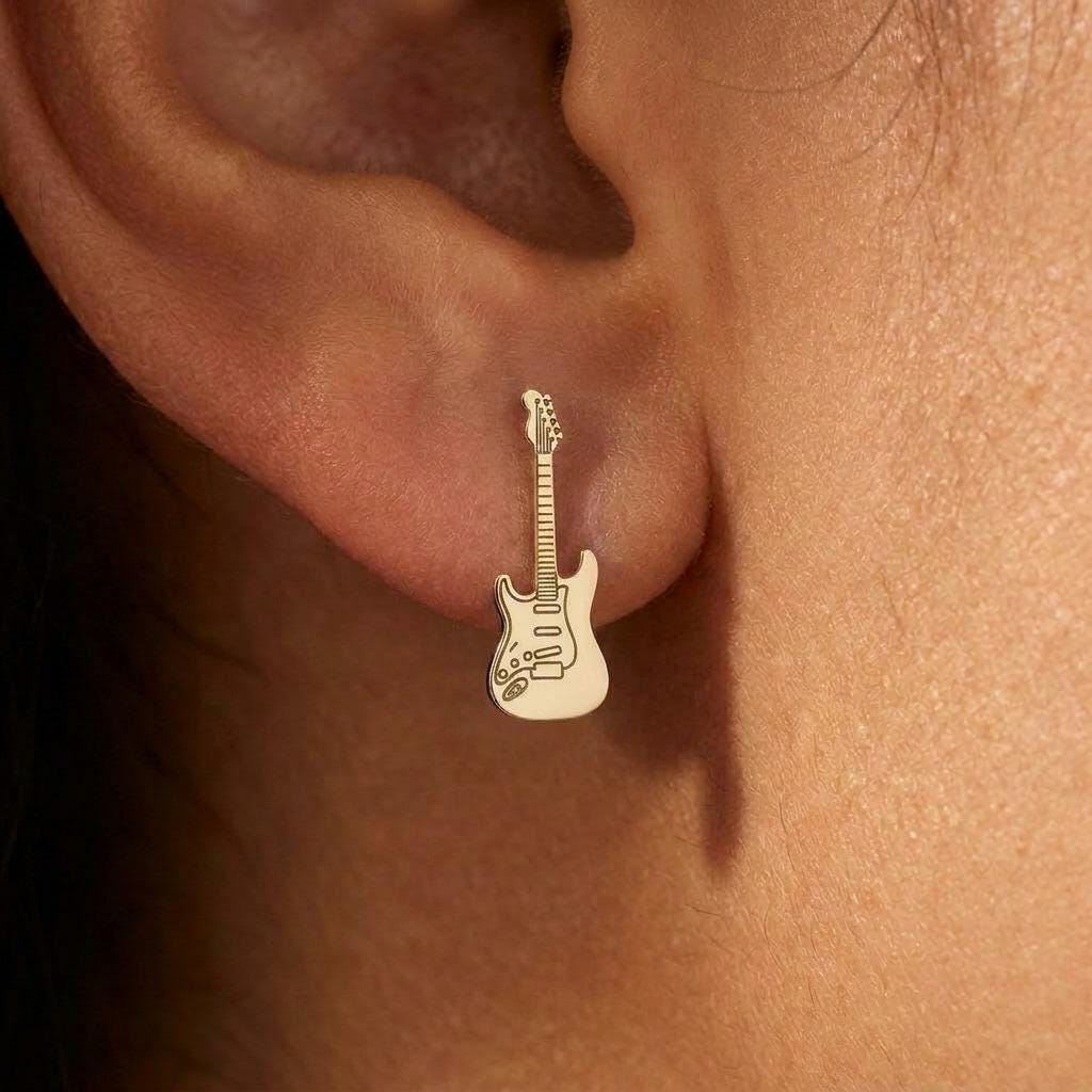 Pair of narrow gold electric guitar stud earrings shown upright. (2 of 9)
