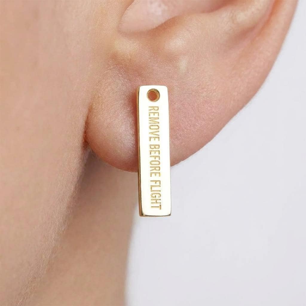 Pair of long narrow gold aviation tag stud earrings with lettering cut across. (2 of 10)