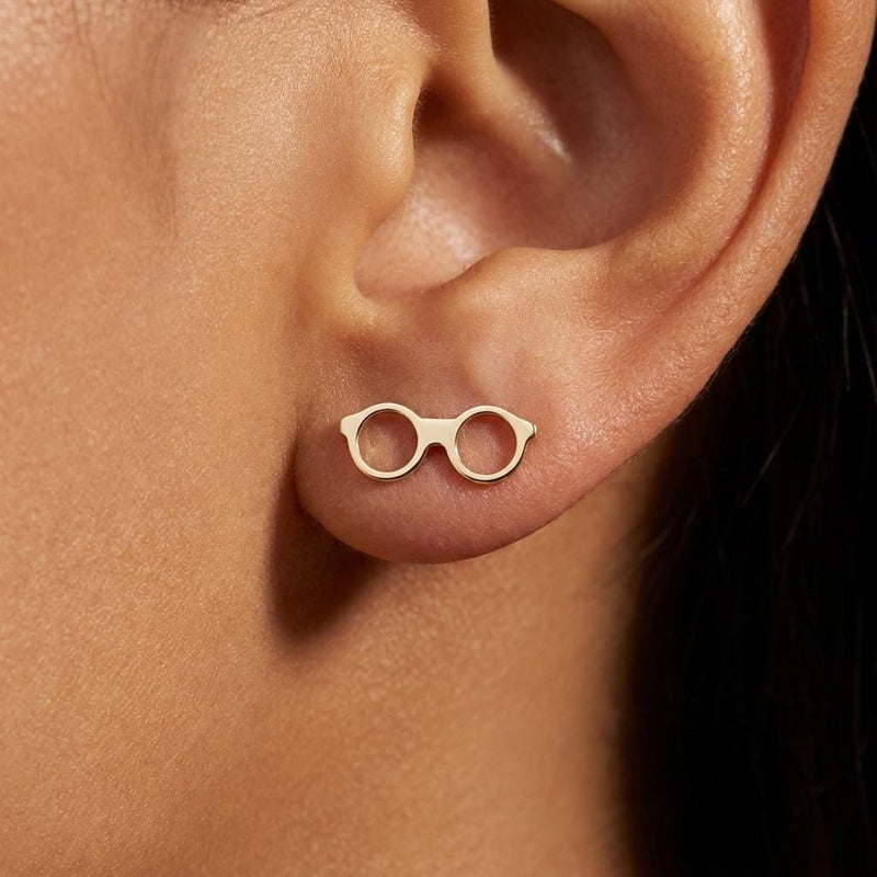 Pair of gold stud earrings shaped like round eyeglasses with open lenses and folded arms (3 of 9)