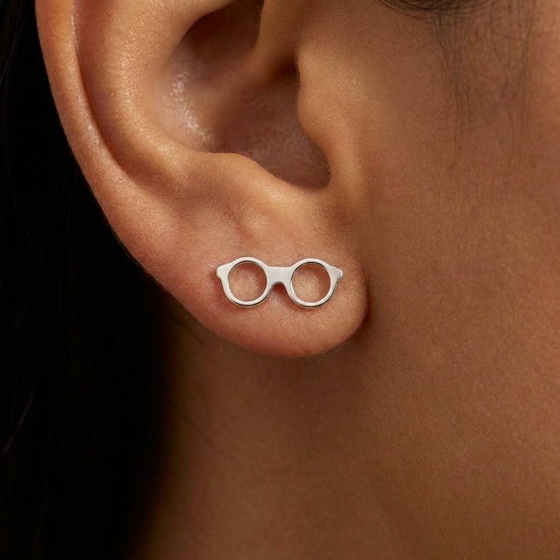 Pair of gold stud earrings shaped like round eyeglasses with open lenses and folded arms (6 of 9)