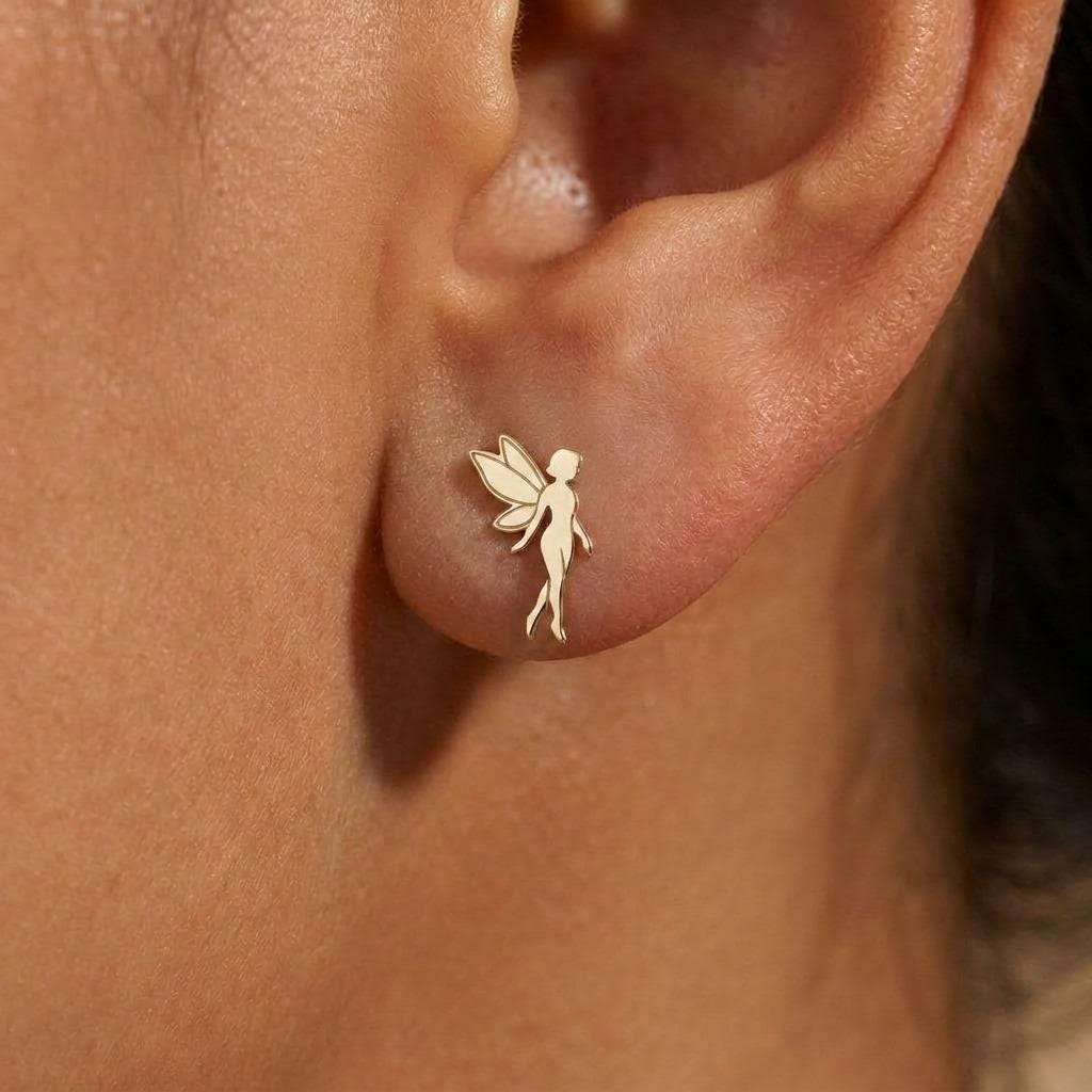 Pair of small gold fairy stud earrings with open wings behind the figure. (2 of 8)
