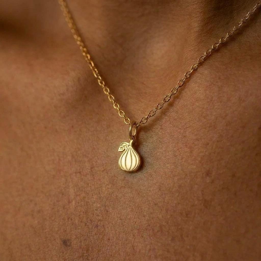 Tiny fig pendant in gold with a short stem, on a fine cable chain