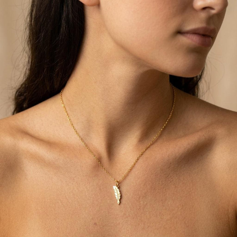 Long narrow gold feather quill pendant with scored barbs on a fine chain. (2 of 10)