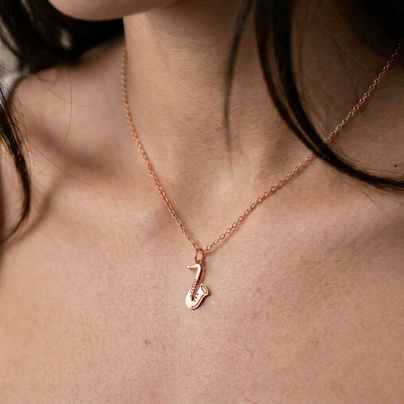 Fine gold chain necklace with a saxophone pendant shown in profile (4 of 8)