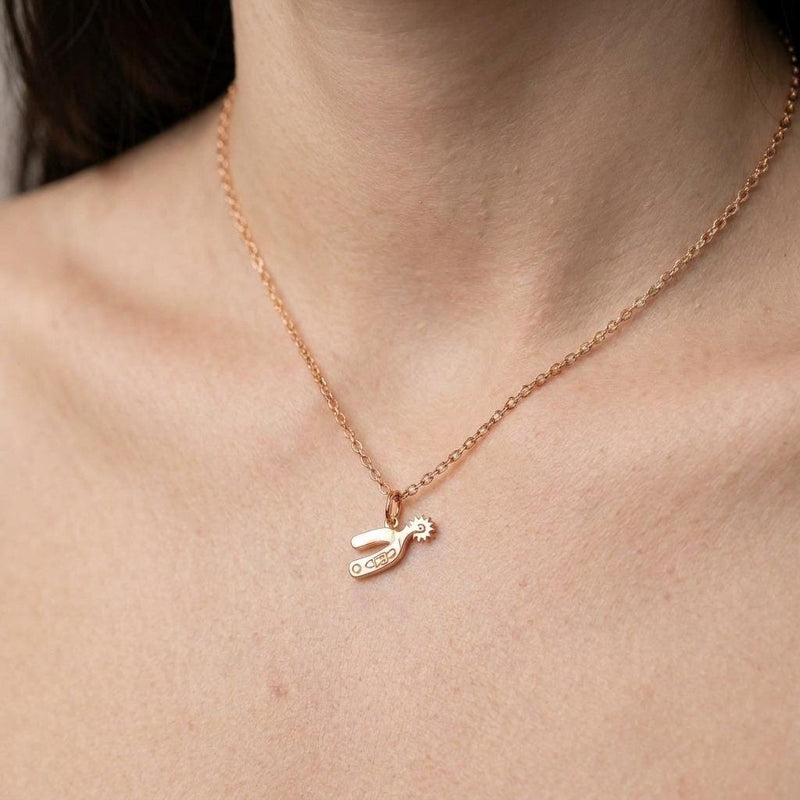 Small gold cowboy spur pendant with rowel hanging from a thin cable chain (2 of 7)