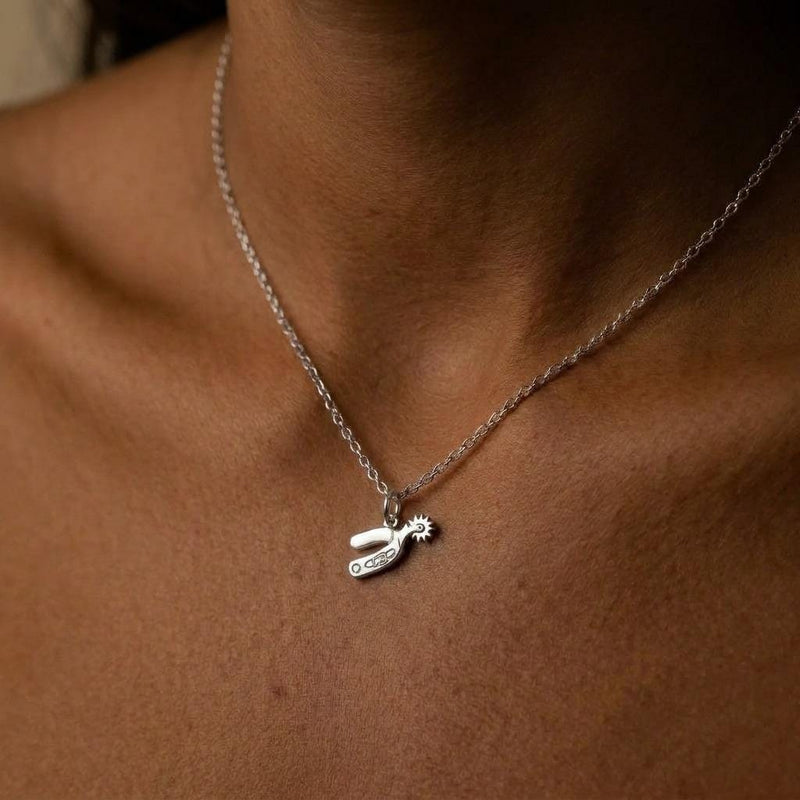 Small gold cowboy spur pendant with rowel hanging from a thin cable chain (3 of 7)