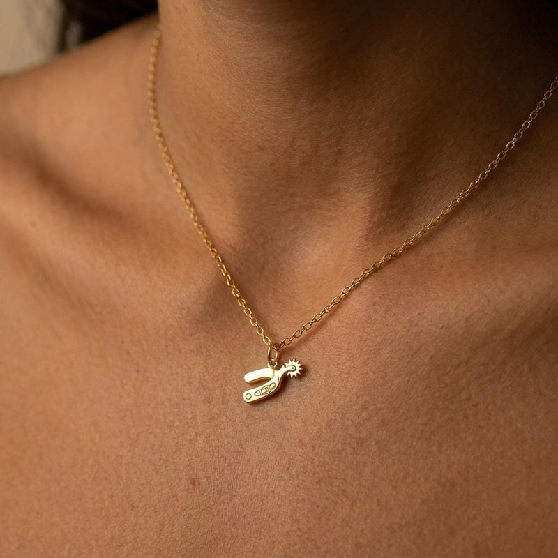 Small gold cowboy spur pendant with rowel hanging from a thin cable chain (4 of 7)