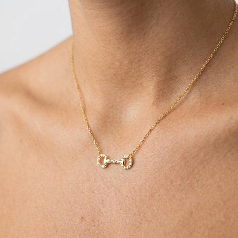 Fine gold chain necklace with a small jointed snaffle horse bit pendant