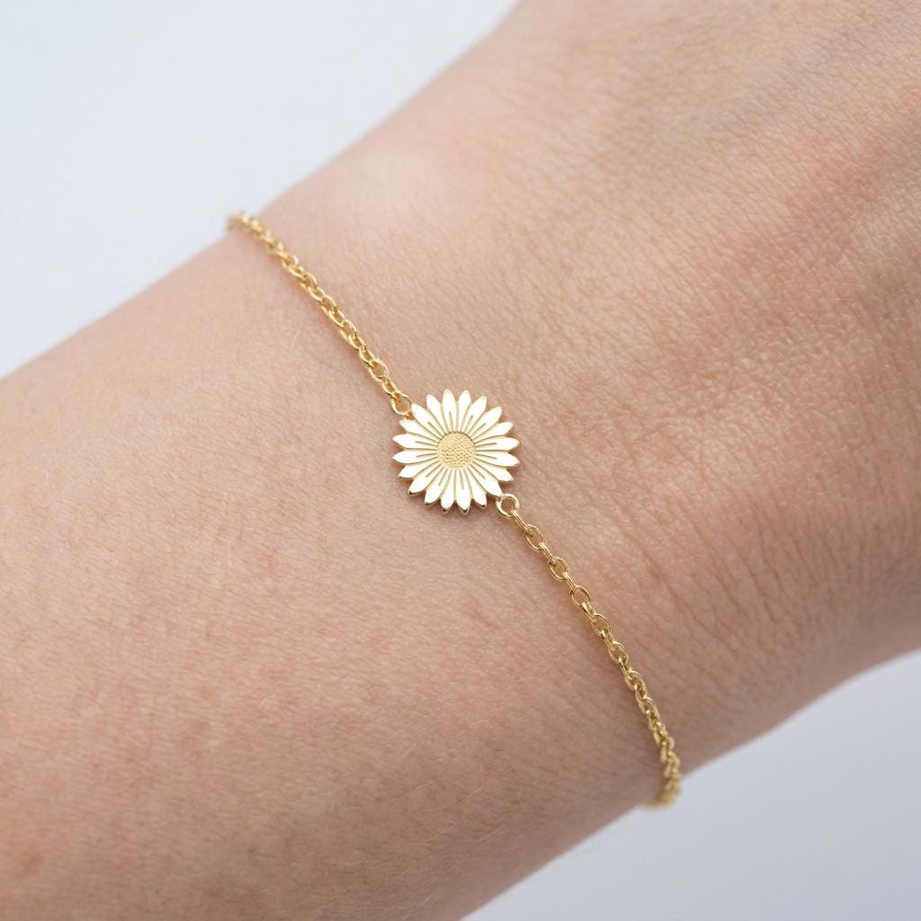Fine gold chain bracelet with a small flat daisy flower charm