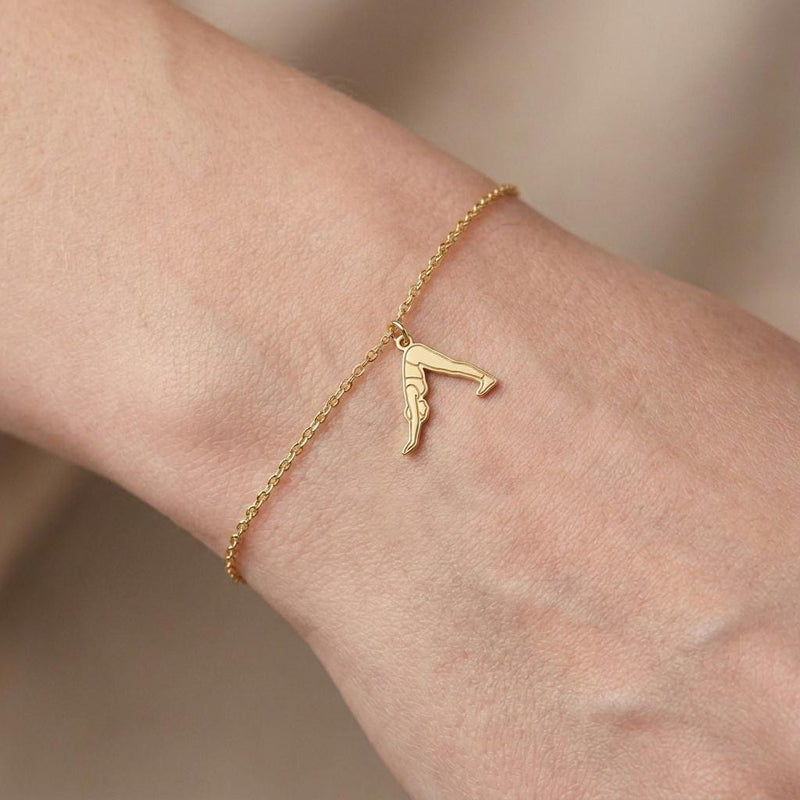 Fine gold chain bracelet with a small charm of a figure in downward dog pose (2 of 7)