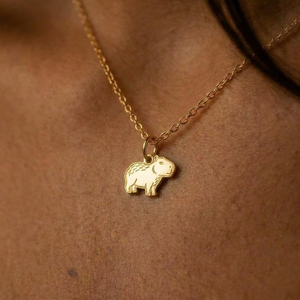 Tiny gold capybara pendant on a fine cable chain with a lobster clasp