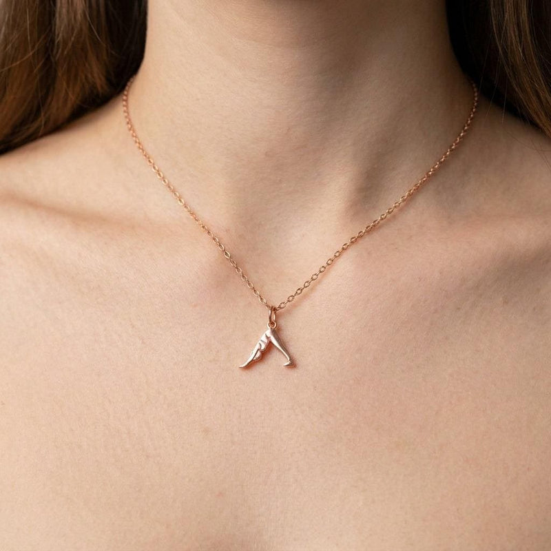 Small gold pendant of a figure in downward dog pose on a fine chain, white background. (5 of 8)