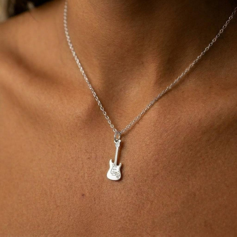 Tiny gold electric guitar pendant hanging from a fine cable chain on a white background. (4 of 9)