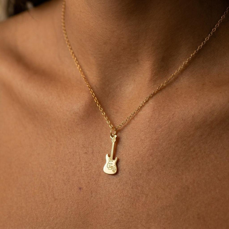 Tiny gold electric guitar pendant hanging from a fine cable chain on a white background. (6 of 9)