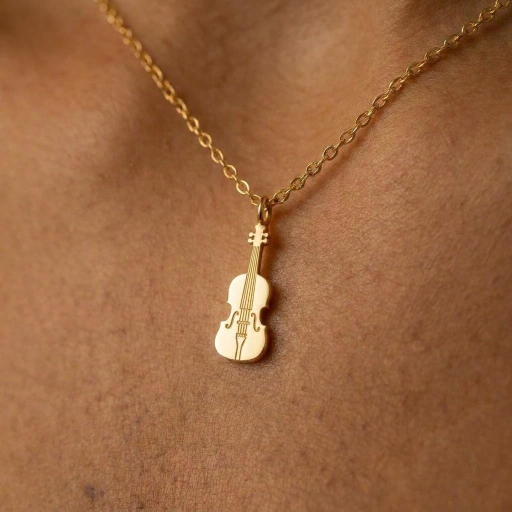 Small gold violin pendant with scroll and f holes hanging upright from a thin chain (2 of 7)
