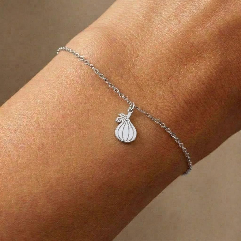 Fine gold chain bracelet with a very small fig charm, shown flat on white (2 of 7)