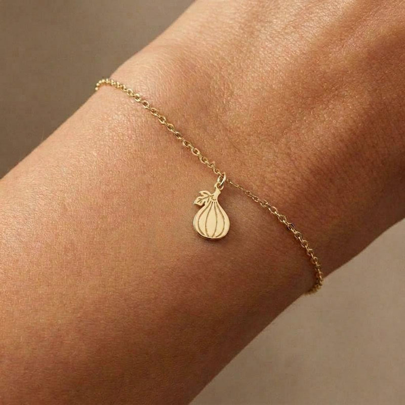 Fine gold chain bracelet with a very small fig charm, shown flat on white (7 of 7)