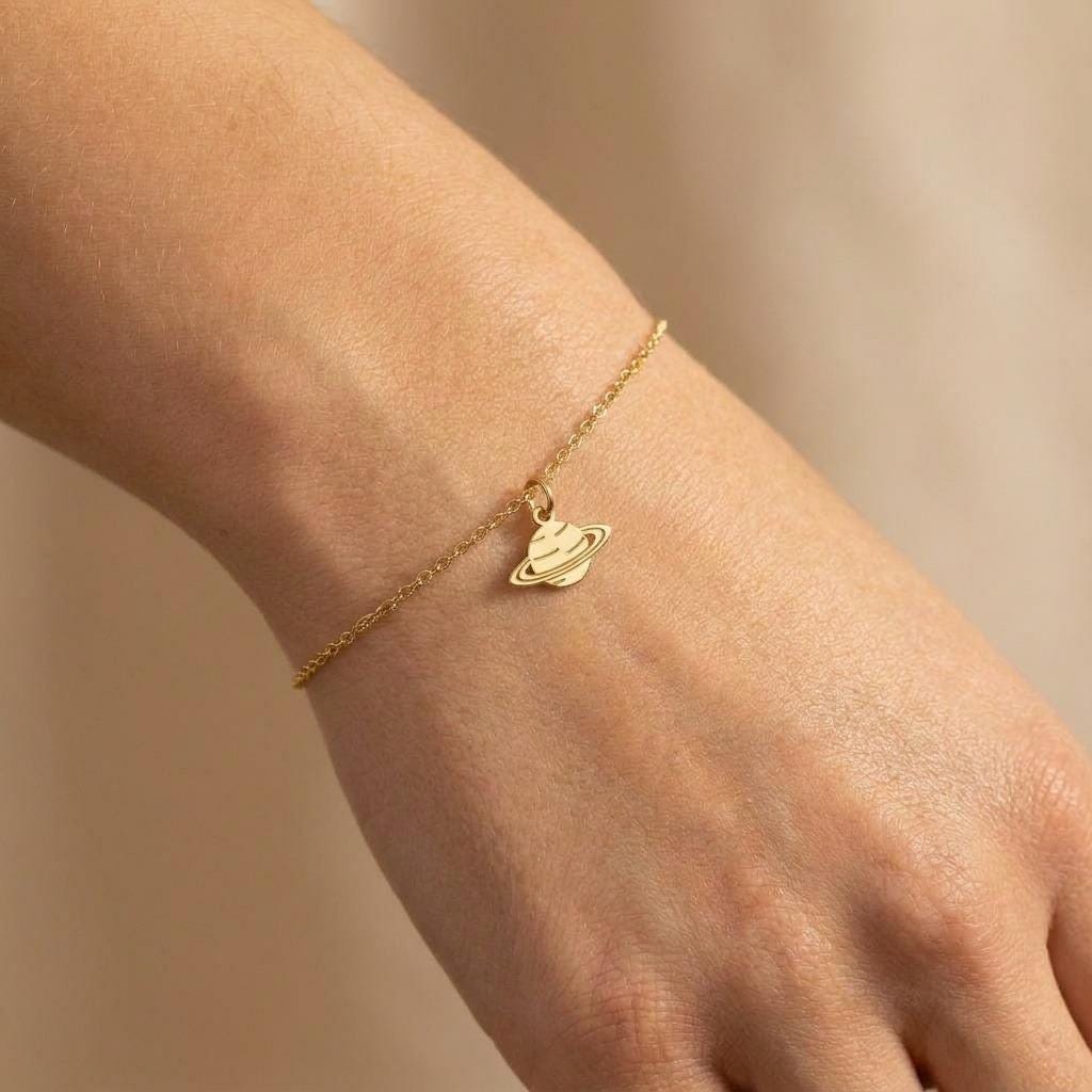 Fine gold bracelet with a small tilted Saturn charm and lobster clasp (2 of 7)