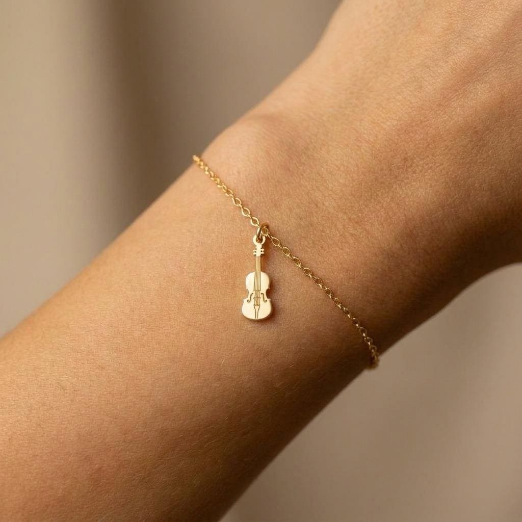 Fine gold chain bracelet with a small detailed violin charm