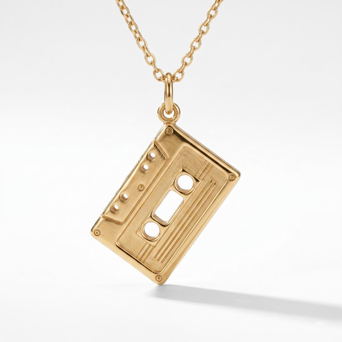 Small gold cassette tape pendant with two reels on a fine cable chain