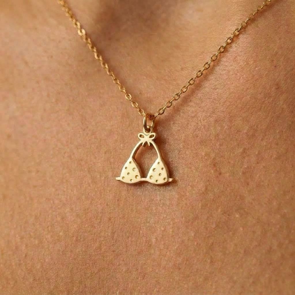 Tiny gold bikini charm pendant on a fine chain, shown on a white background.