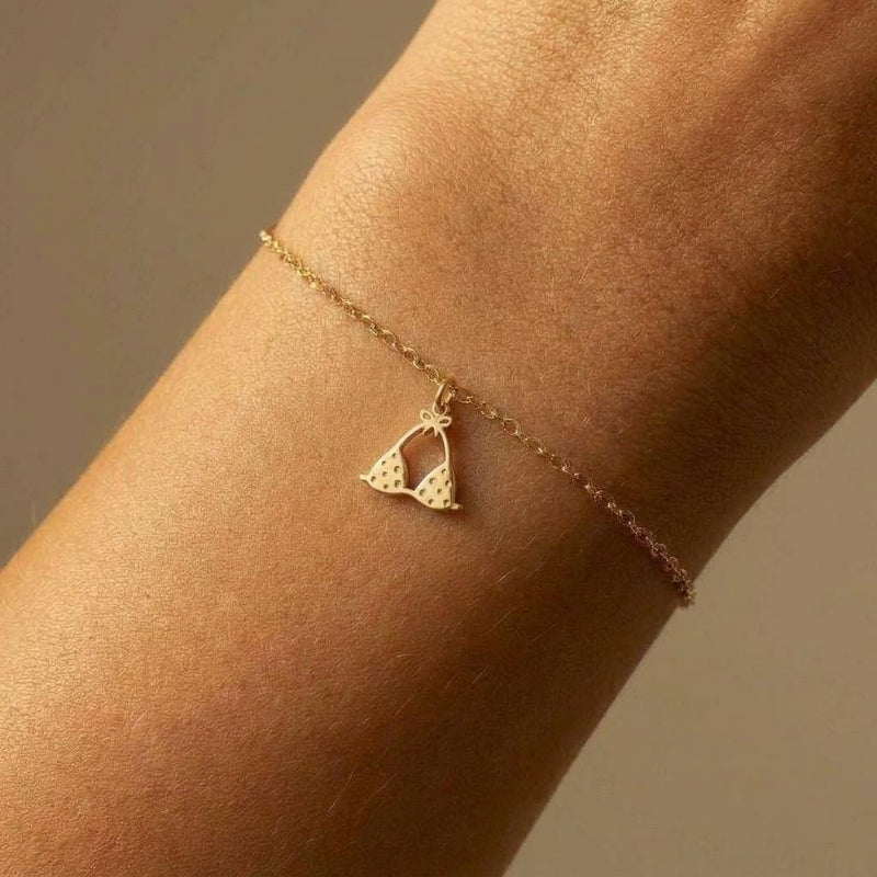 Tiny gold bikini charm on a delicate bracelet chain with clasp, white background. (2 of 7)