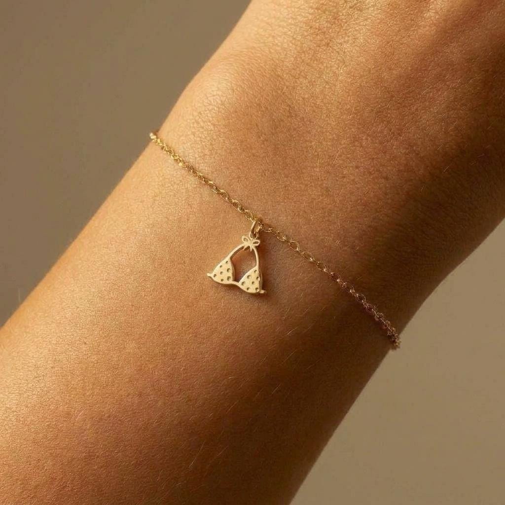 Tiny gold bikini charm on a delicate bracelet chain with clasp, white background. (2 of 7)