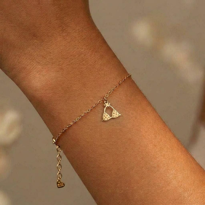 Tiny gold bikini charm on a delicate bracelet chain with clasp, white background. (3 of 7)