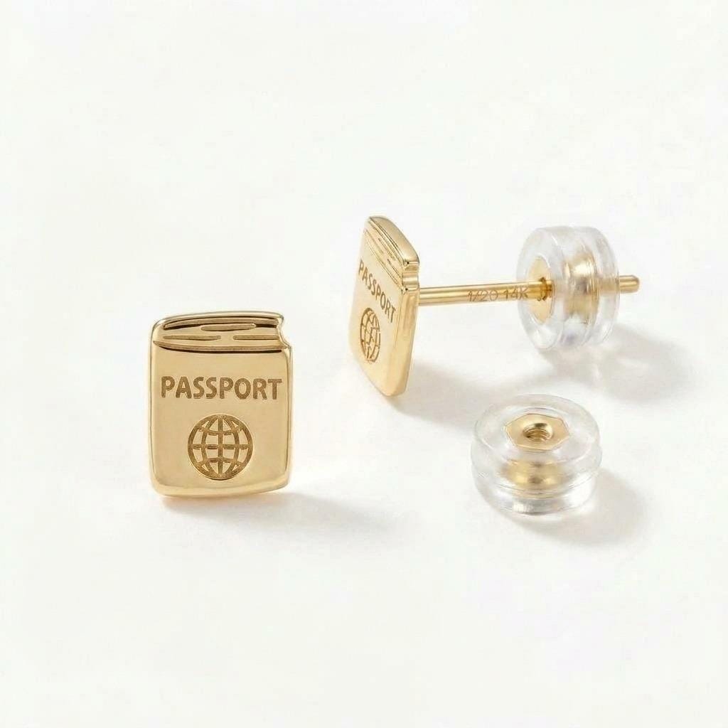 Pair of tiny gold passport stud earrings shown on a white background.