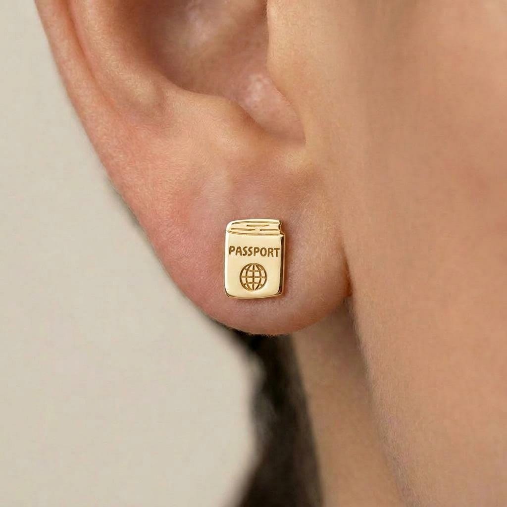 Pair of tiny gold passport stud earrings shown on a white background. (2 of 5)