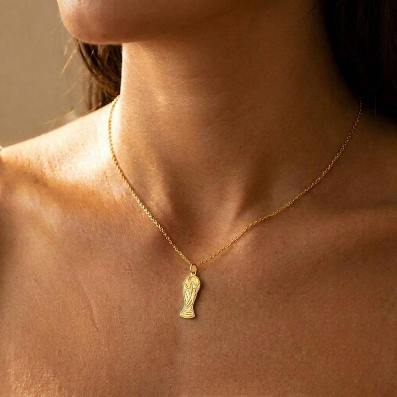 Small gold soccer trophy pendant on a fine cable chain, photographed on white (3 of 6)