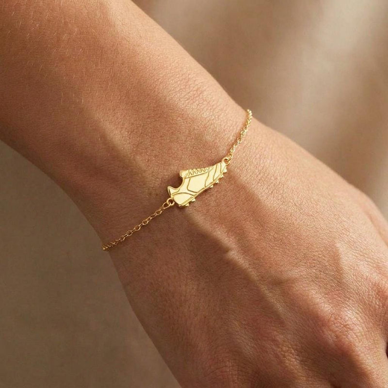 Fine gold chain bracelet with a small soccer cleat charm and lobster clasp