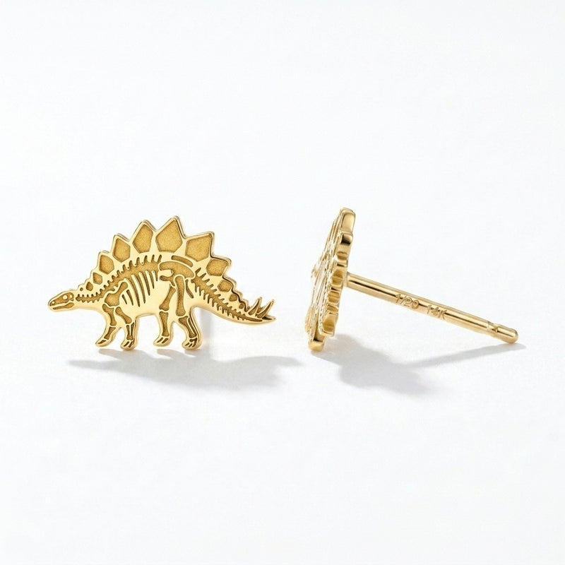 Pair of gold stegosaurus skeleton stud earrings showing back plates and tail spikes