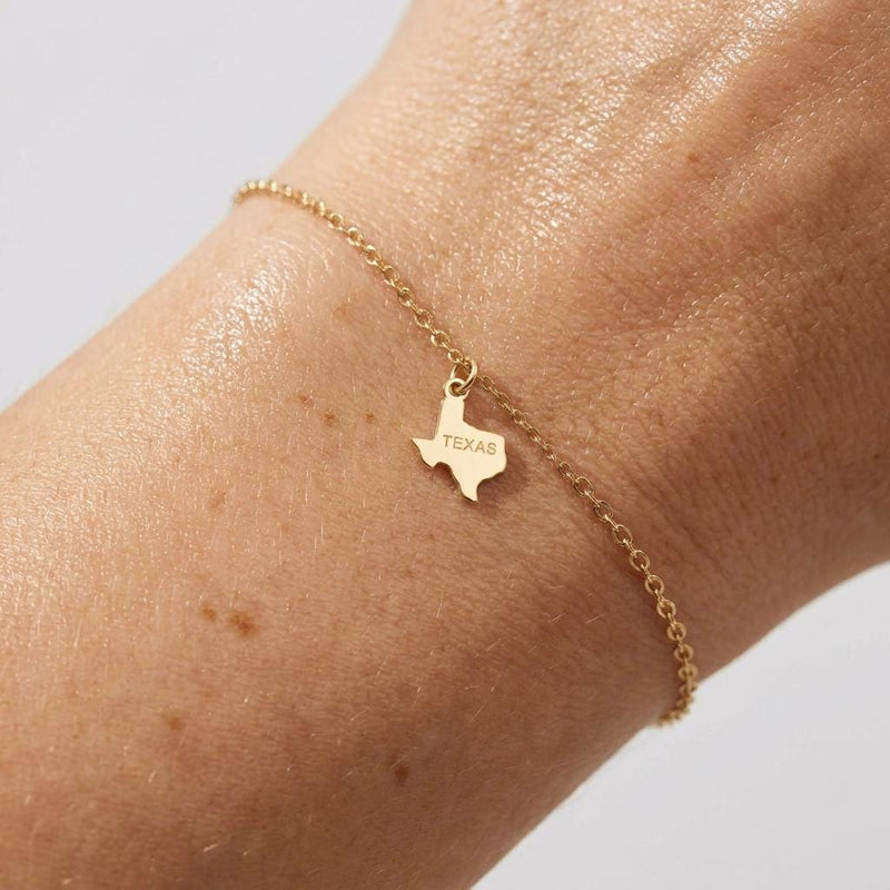 Fine chain bracelet with a small flat Texas state outline charm in gold