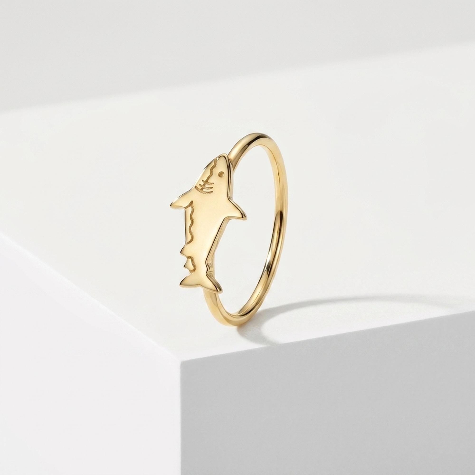 Thin gold ring with a small sculpted shark lying across the top of the band (2 of 7)