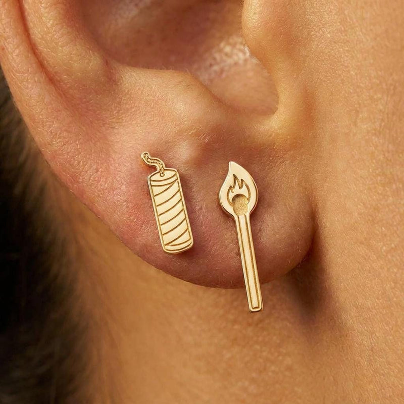 Mismatched gold earrings, a struck match on one side and a firecracker with a fuse on the other (2 of 8)