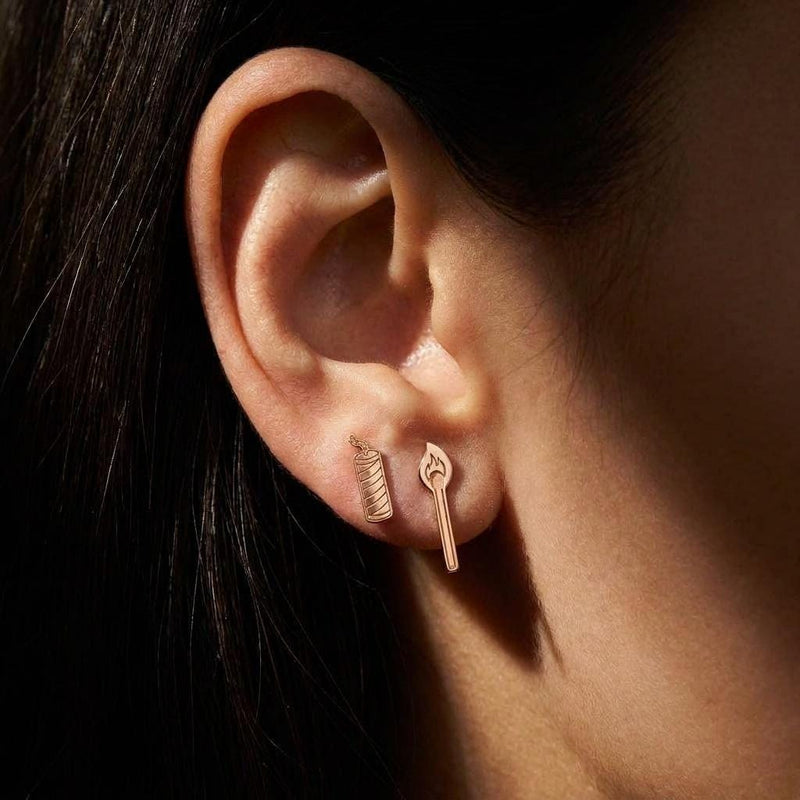 Mismatched gold earrings, a struck match on one side and a firecracker with a fuse on the other (4 of 8)