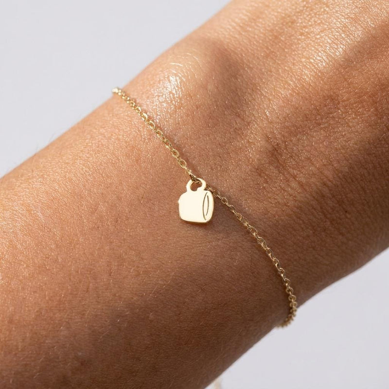 Fine gold chain bracelet with a small coffee cup charm and lobster clasp.