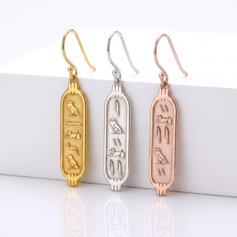 Pair of narrow oval Egyptian cartouche earrings in gold with vertical carved marks down the center